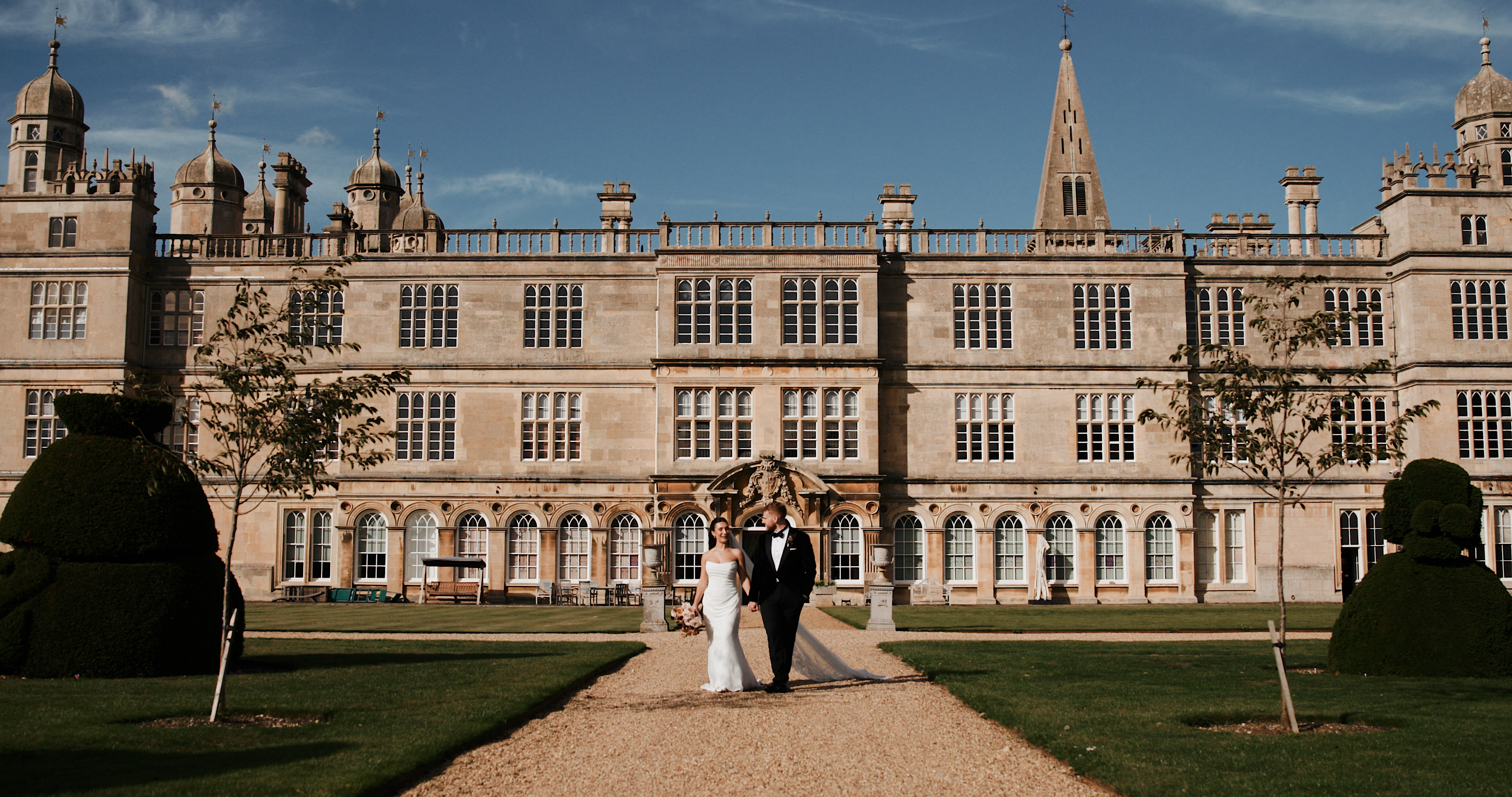 Eloise and Jake’s elegant Burghley House wedding captured on film by Lincolnshire Videography, featuring the couple outside the grand stately home in Stamford.